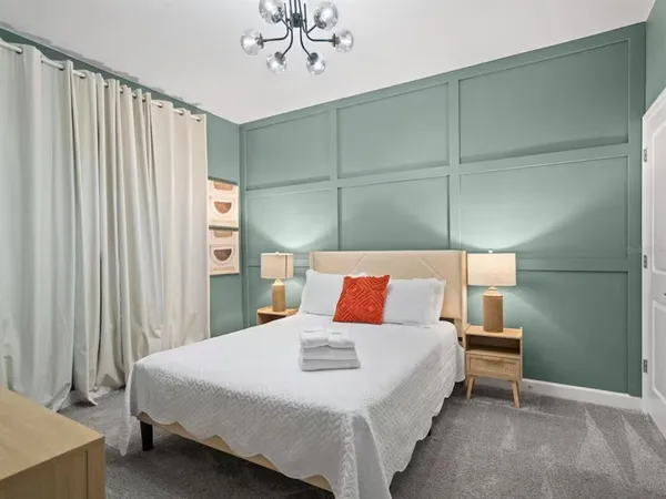 a bedroom with a bed and a chandelier
