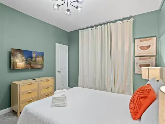 a bedroom with a bed and a flat screen tv