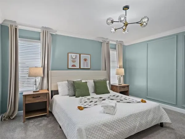 a bedroom with a large bed and a chandelier