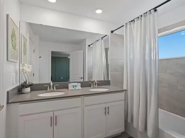 a bathroom with a double vanity sink and mirror