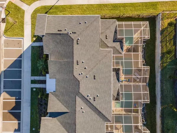 an aerial view of a house with a garden and lake view