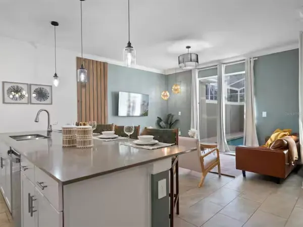 a kitchen with granite countertop a sink a counter top space and living room view