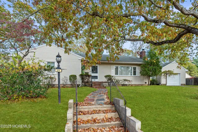 a front view of a house with a yard and trees