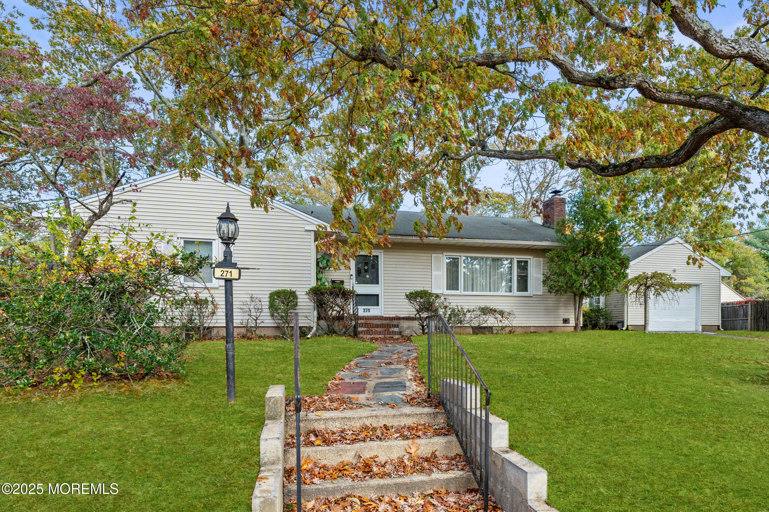 a front view of a house with a yard and trees