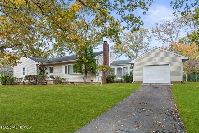 a front view of a house with a garden and trees