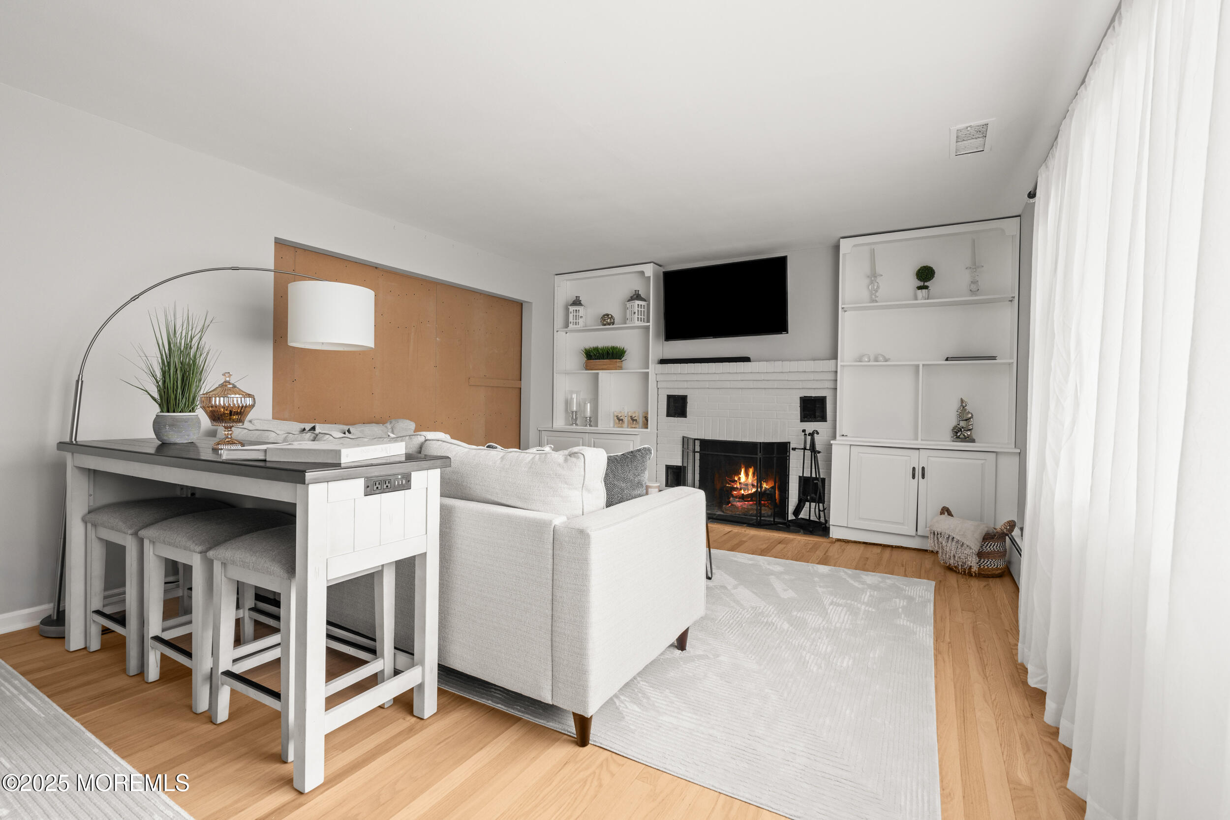 271 Jerome Avenue Oakhurst, NJ 07755 - Photo 8 of 39 a living room with furniture a flat screen tv and a fireplace