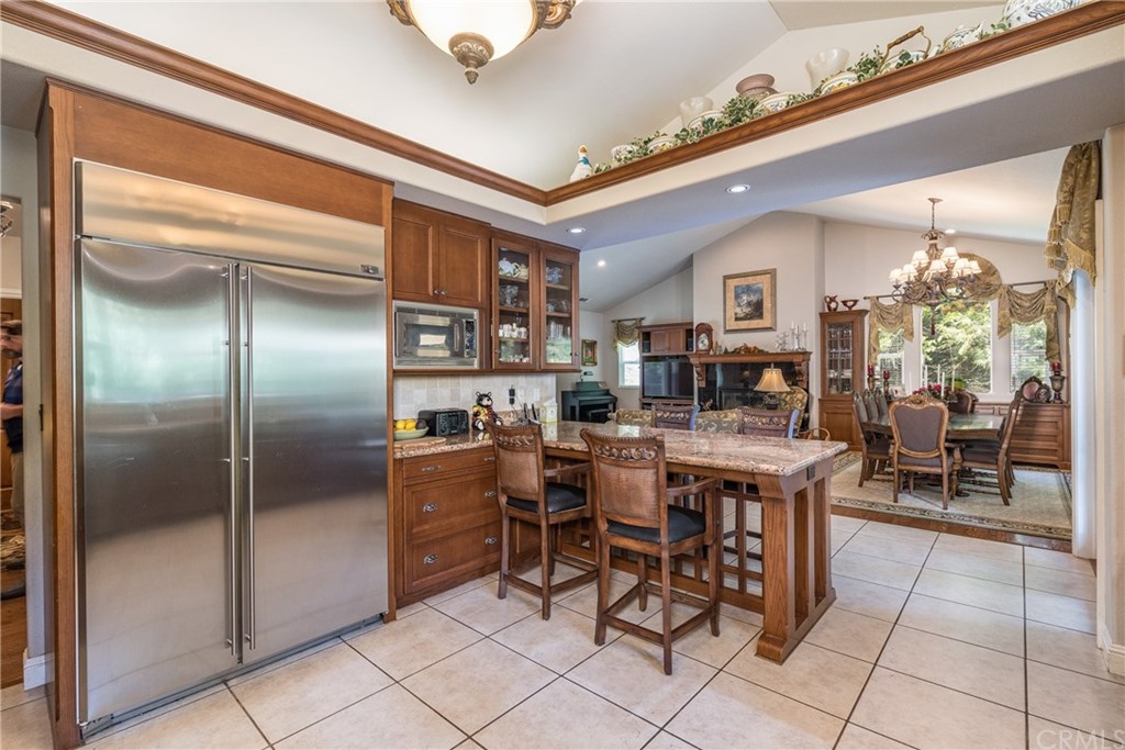 7703 Forest Drive Fish Camp, CA 93623 - Photo 18 of 48 a kitchen with stainless steel appliances granite countertop a table chairs sink and cabinets