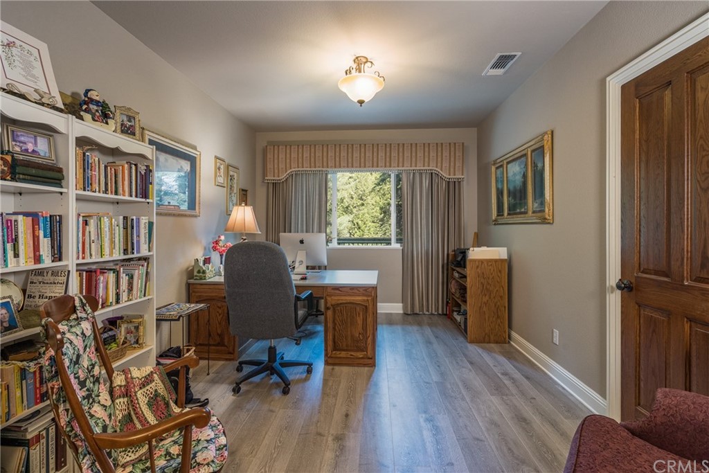 7703 Forest Drive Fish Camp, CA 93623 - Photo 20 of 48 a view of a workspace with furniture and a bookshelf