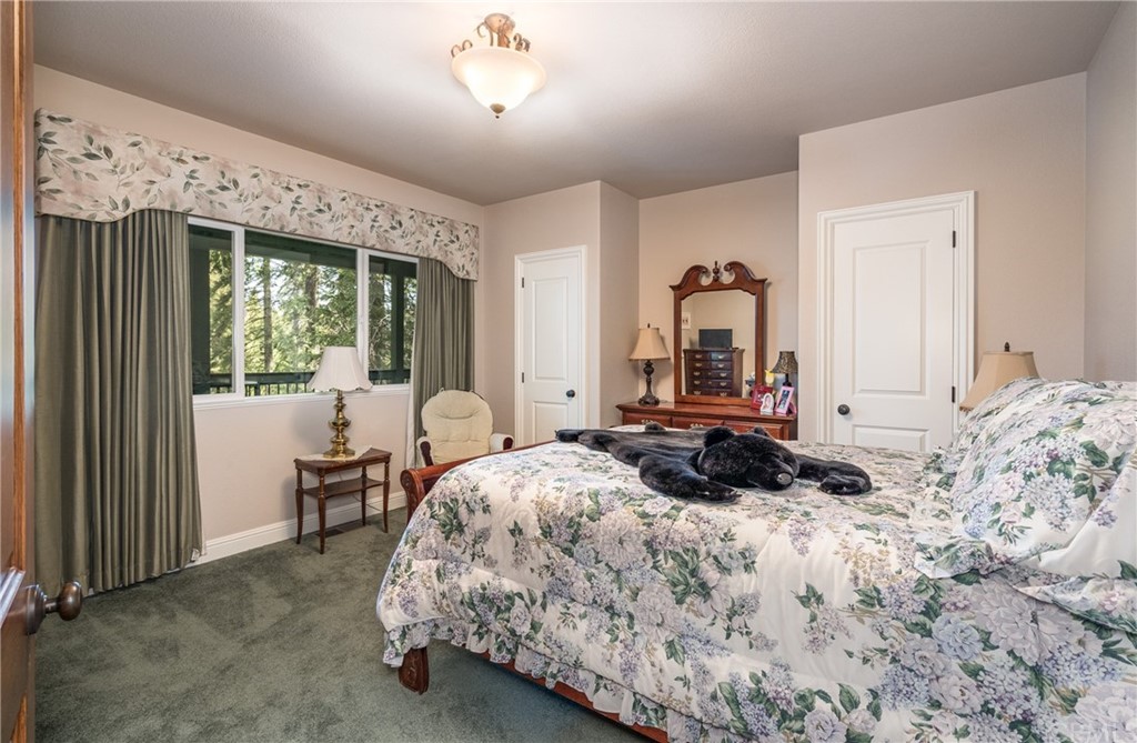 7703 Forest Drive Fish Camp, CA 93623 - Photo 29 of 48 a bedroom with a bed and large windows