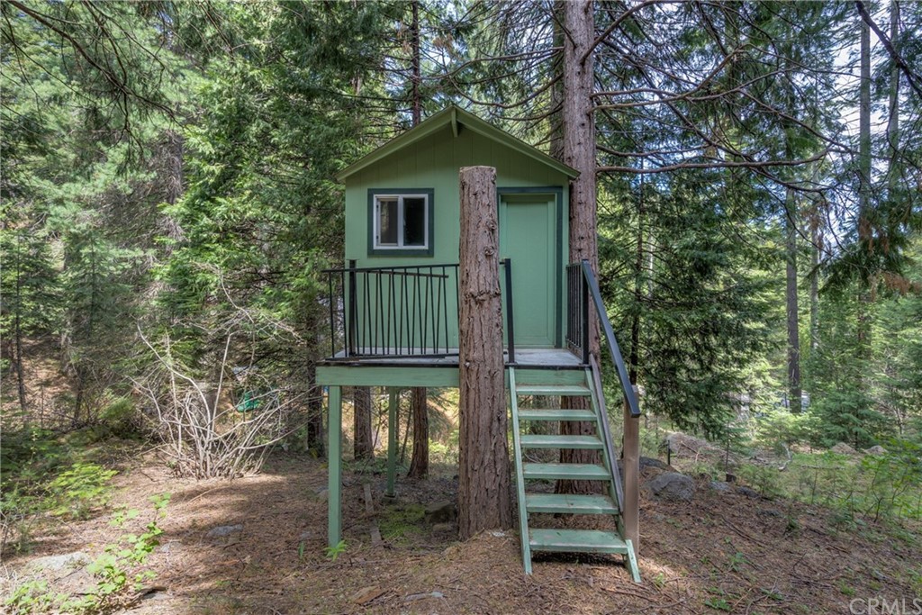 7703 Forest Drive Fish Camp, CA 93623 - Photo 47 of 48 a front view of a house with a yard and balcony