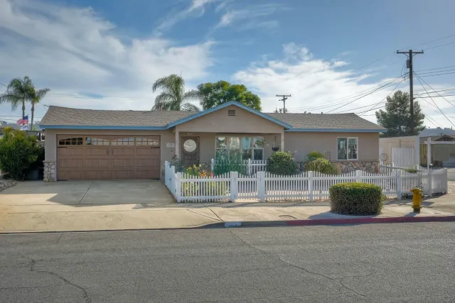 a front view of a house with a garden and plants