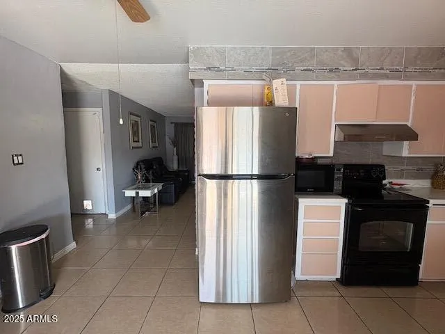 a kitchen with a refrigerator and a stove top oven