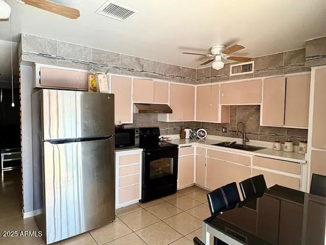 a kitchen with a refrigerator a sink and cabinets