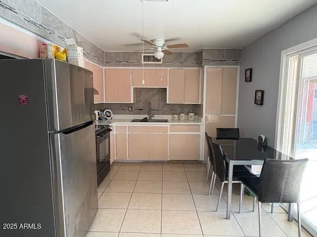 a kitchen with stainless steel appliances a refrigerator a stove a sink and chairs