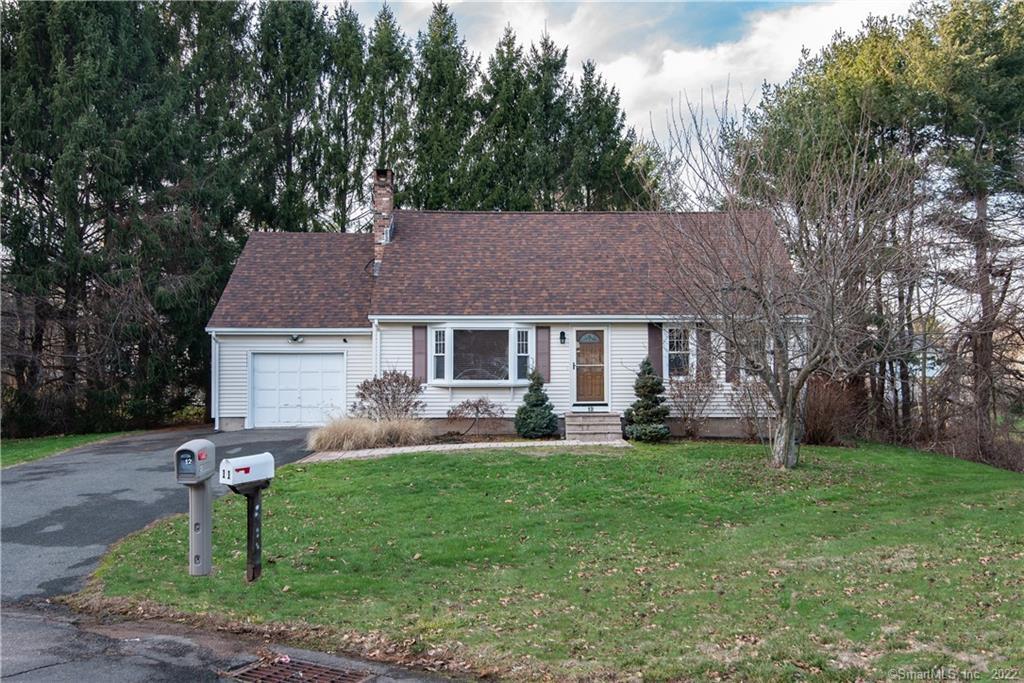 a front view of a house with a yard and trees