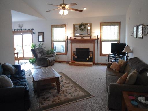 23319 Lucas Road DeKalb, IL 60115 - Photo 2 of 14 a living room with furniture a fireplace and a flat screen tv