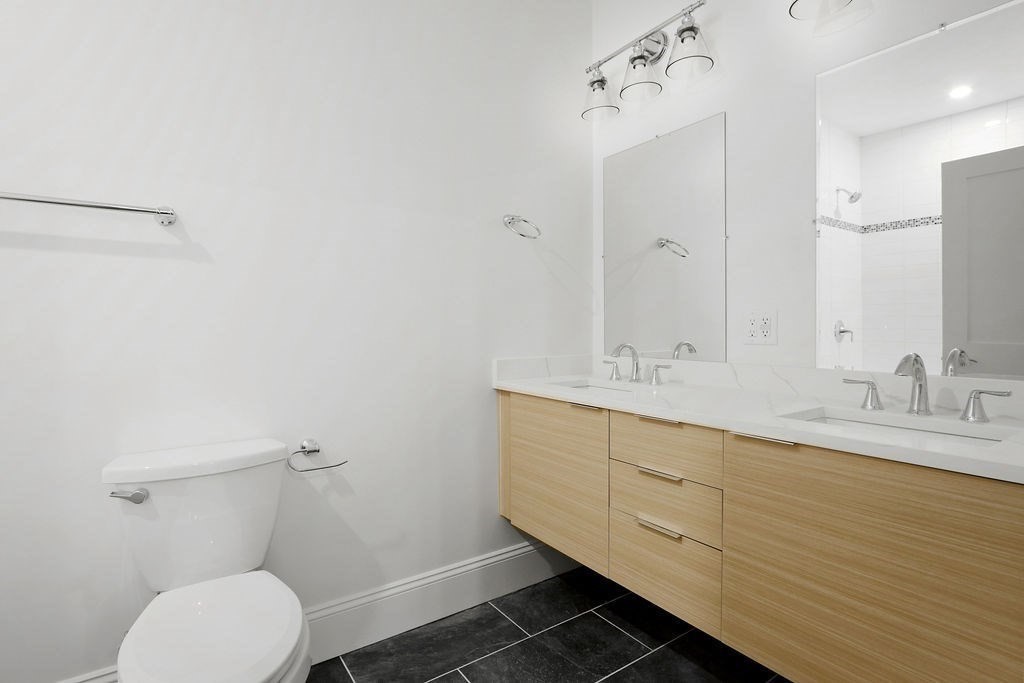 21 Glen Road, Unit 14 Boston, MA 02130 - Photo 6 of 7 a bathroom with a toilet sink and mirror