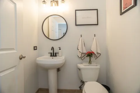 a bathroom with a toilet a sink and mirror