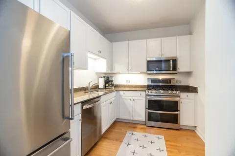 a kitchen with stainless steel appliances granite countertop a stove a sink and a refrigerator