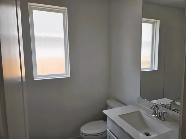 a bathroom with a sink toilet and mirror