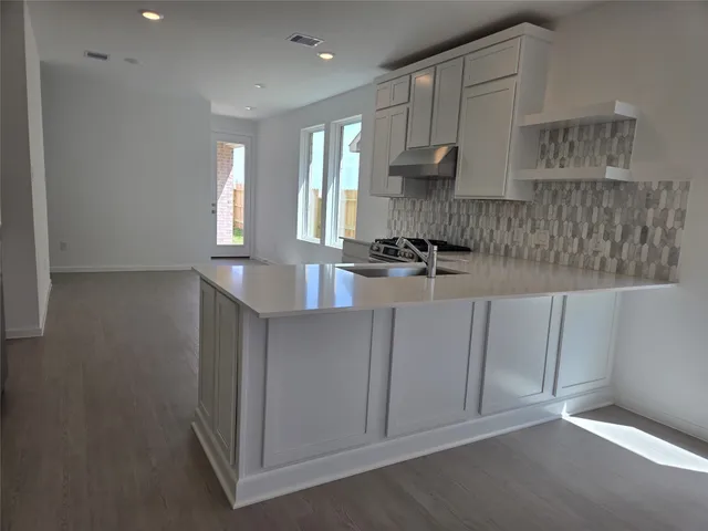 a kitchen with stainless steel appliances granite countertop a stove and a refrigerator