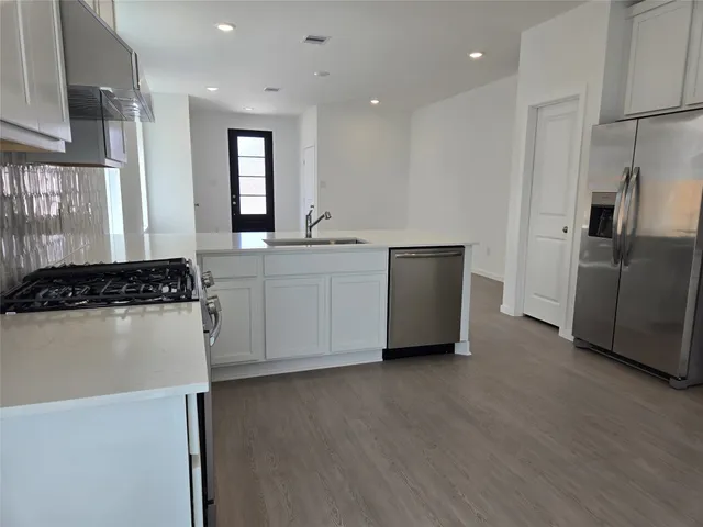 a kitchen with stainless steel appliances a refrigerator and a stove