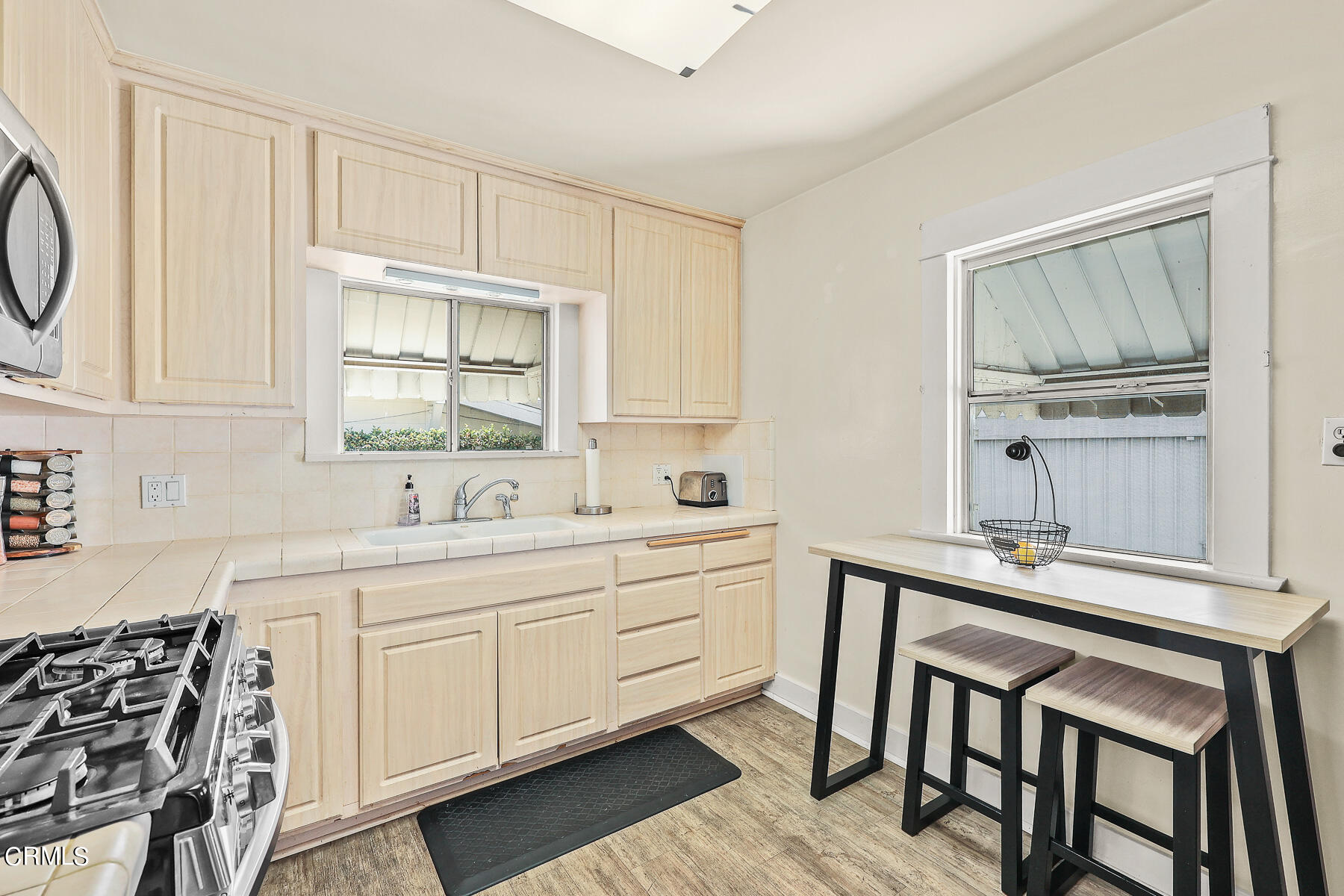 1159 Western Avenue Glendale, CA 91201 - Photo 11 of 52 a kitchen with stainless steel appliances a sink a stove and white cabinets with wooden floor