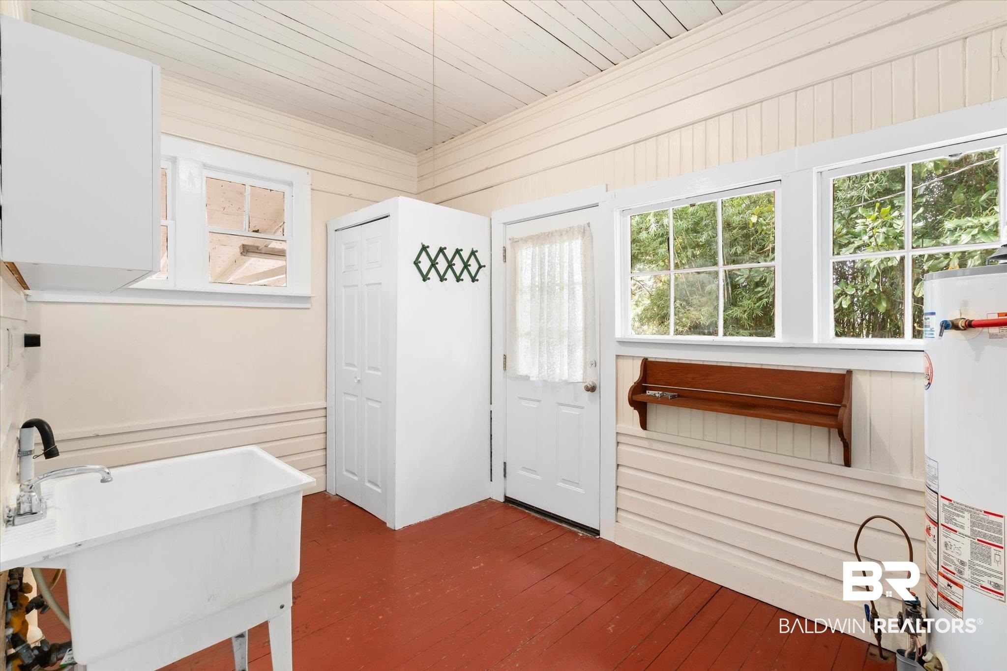 211 3rd Street Mobile, AL 36611 - Photo 17 of 20 Bathroom with water heater, wood ceiling, wood walls, hardwood / wood-style floors, and sink