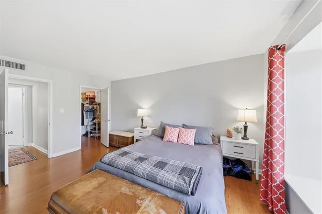 a bedroom with a bed and wooden floor