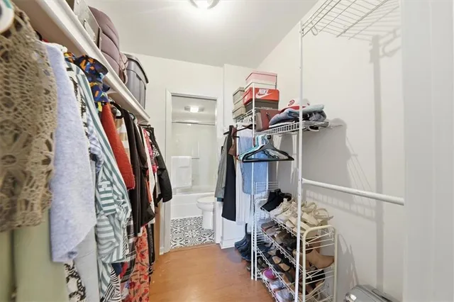 a view of walk in closet with clothes