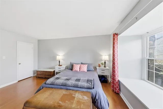 a bedroom with a bed and a large window