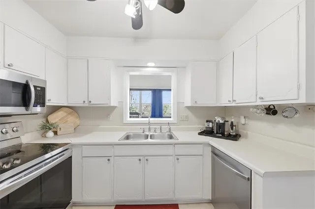 a kitchen with sink cabinets and appliances