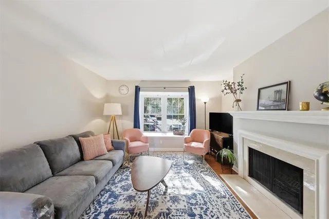 a living room with furniture a fireplace and a large window