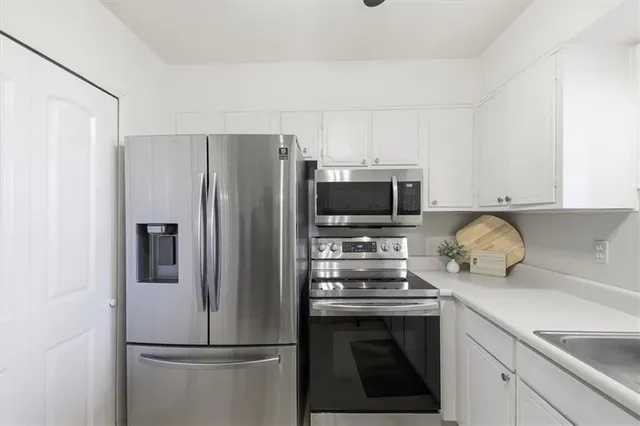 a kitchen with stainless steel appliances a refrigerator stove and microwave