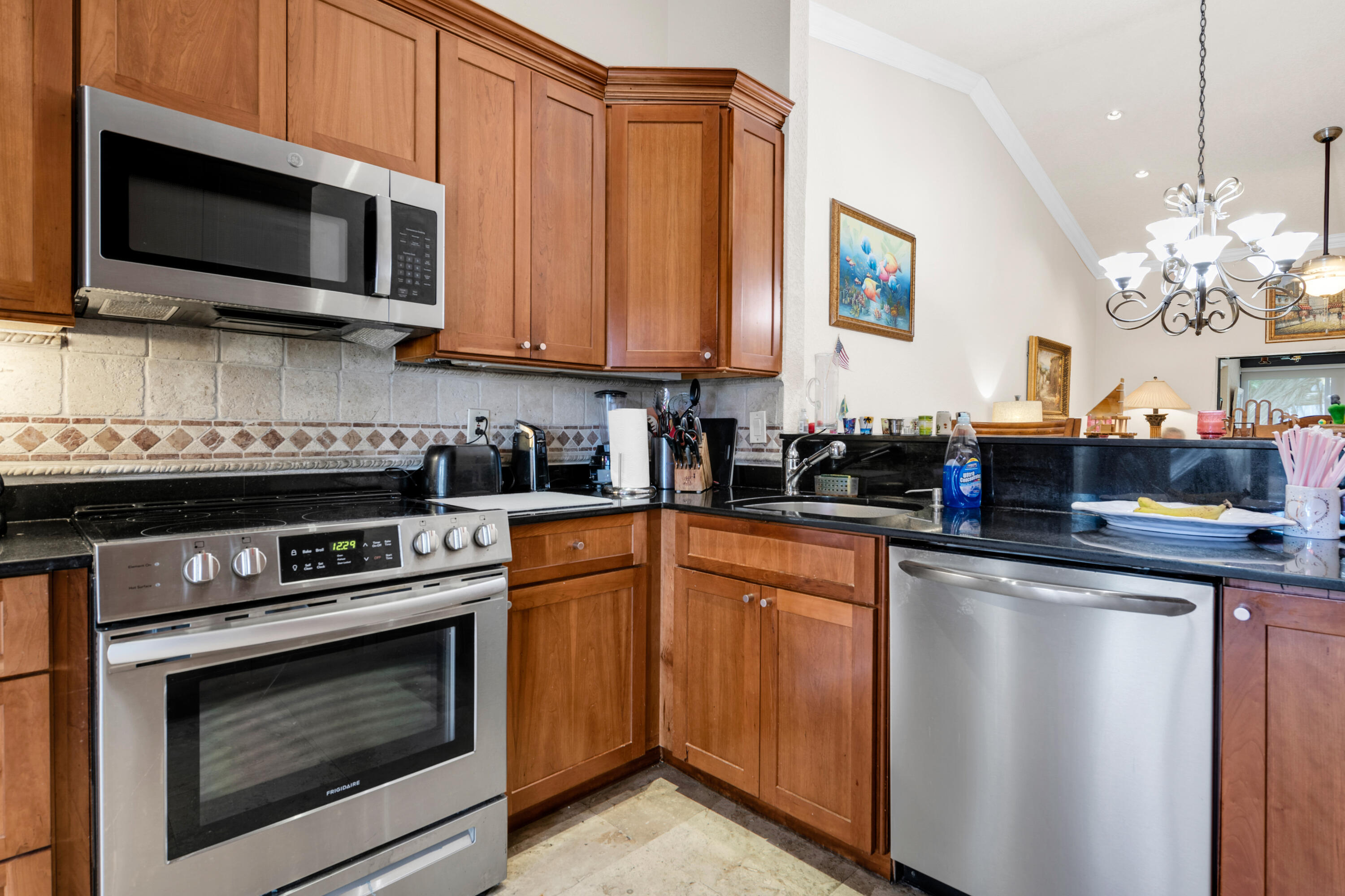 8440 Boca Glades Boulevard East Boca Raton, FL 33434 - Photo 3 of 16 a kitchen with stainless steel appliances granite countertop a stove microwave and cabinets