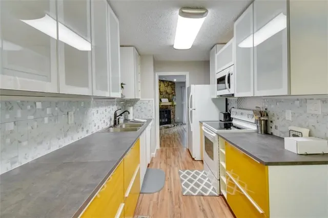a kitchen with a sink a counter top space stainless steel appliances and cabinets