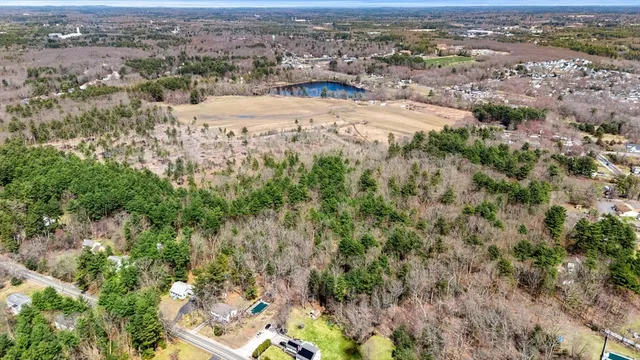 an aerial view of residential houses with outdoor space and trees
