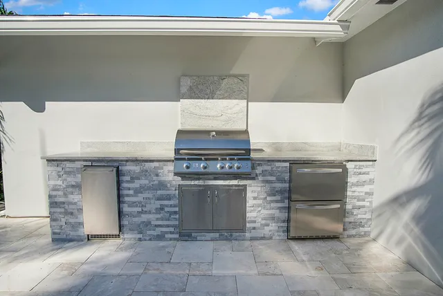 a view of kitchen with stainless steel appliances cabinets and fireplace