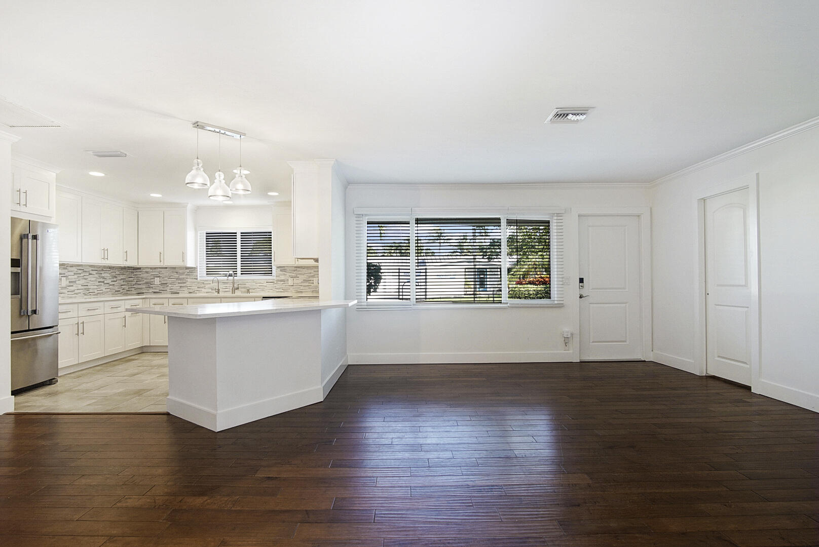 924 Pompano Drive Jupiter, FL 33458 - Photo 9 of 36 a large white kitchen with wooden floors and white walls