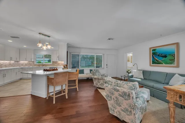 a living room with furniture wooden floor and a large window