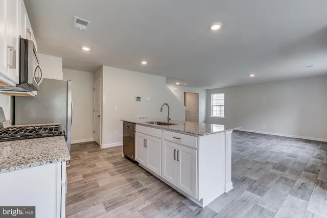 a kitchen with stainless steel appliances granite countertop a sink and cabinets