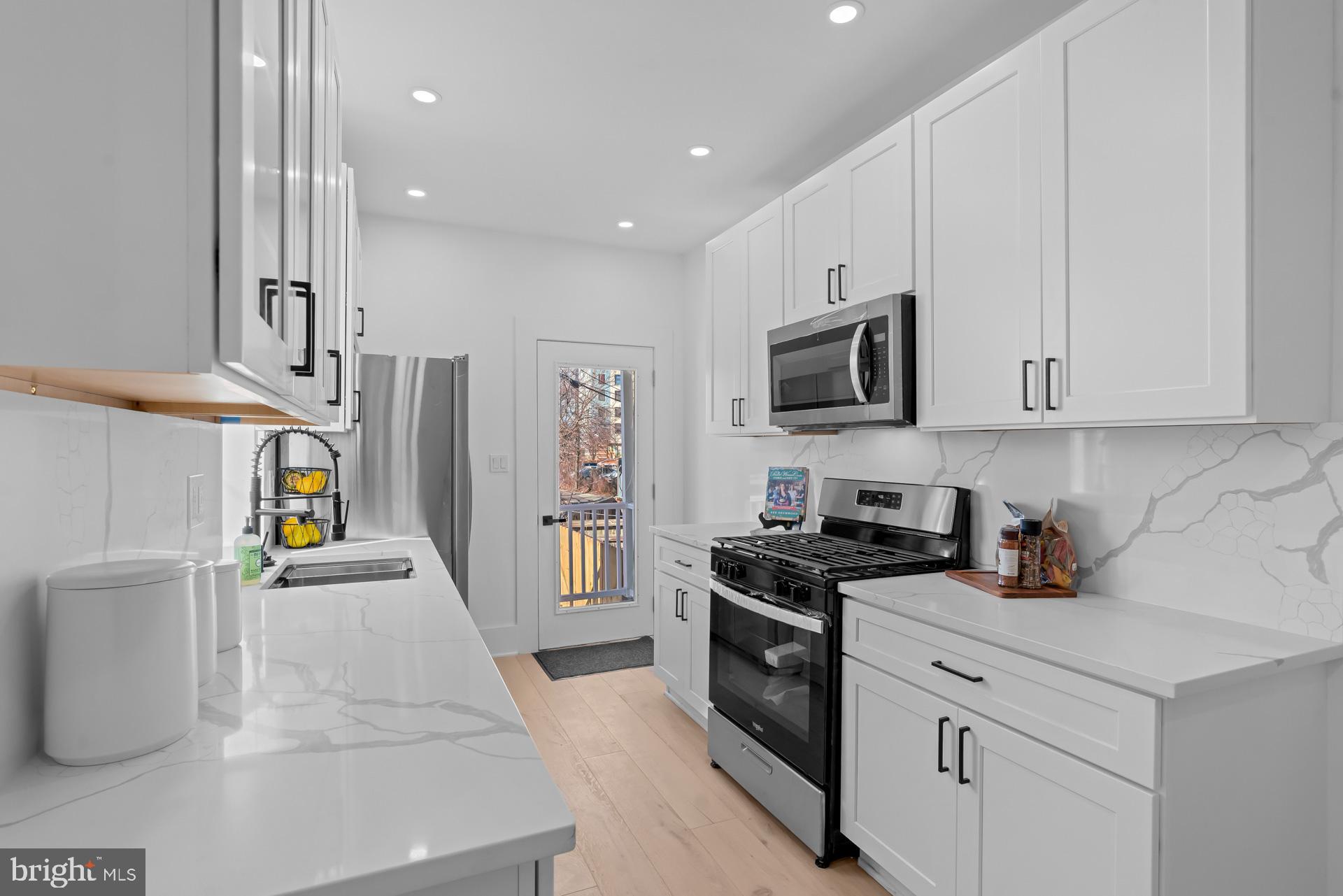 939 Shepherd Street Northwest Washington, DC 20011 - Photo 17 of 45 a kitchen with stainless steel appliances granite countertop a stove a sink and a microwave