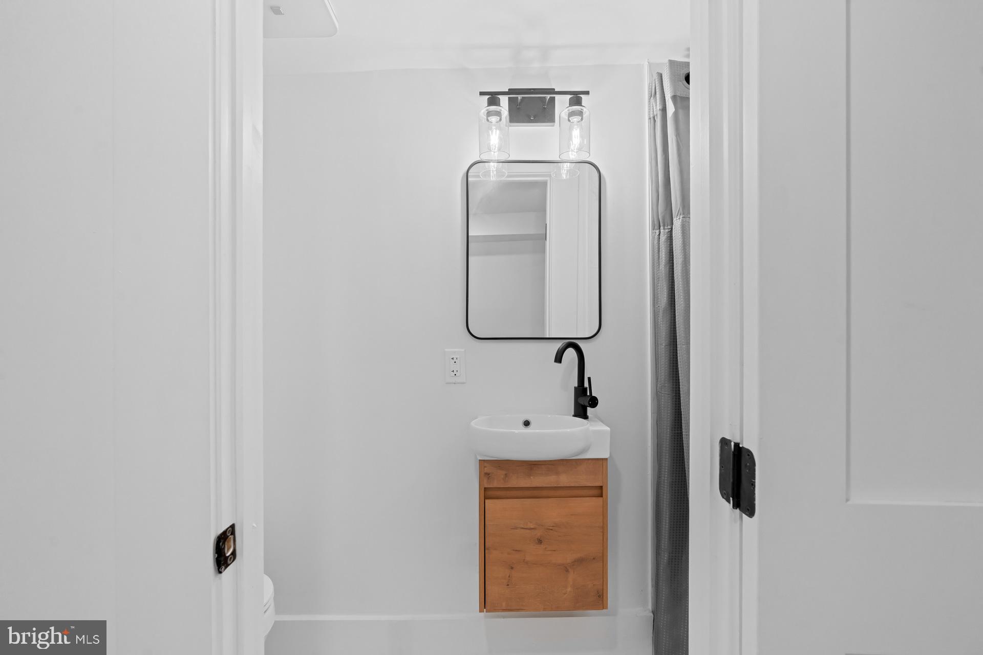 939 Shepherd Street Northwest Washington, DC 20011 - Photo 22 of 45 a bathroom with a mirror and vanity