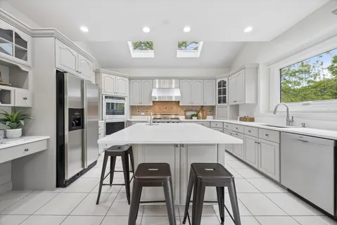 a kitchen with a table chairs refrigerator and cabinets