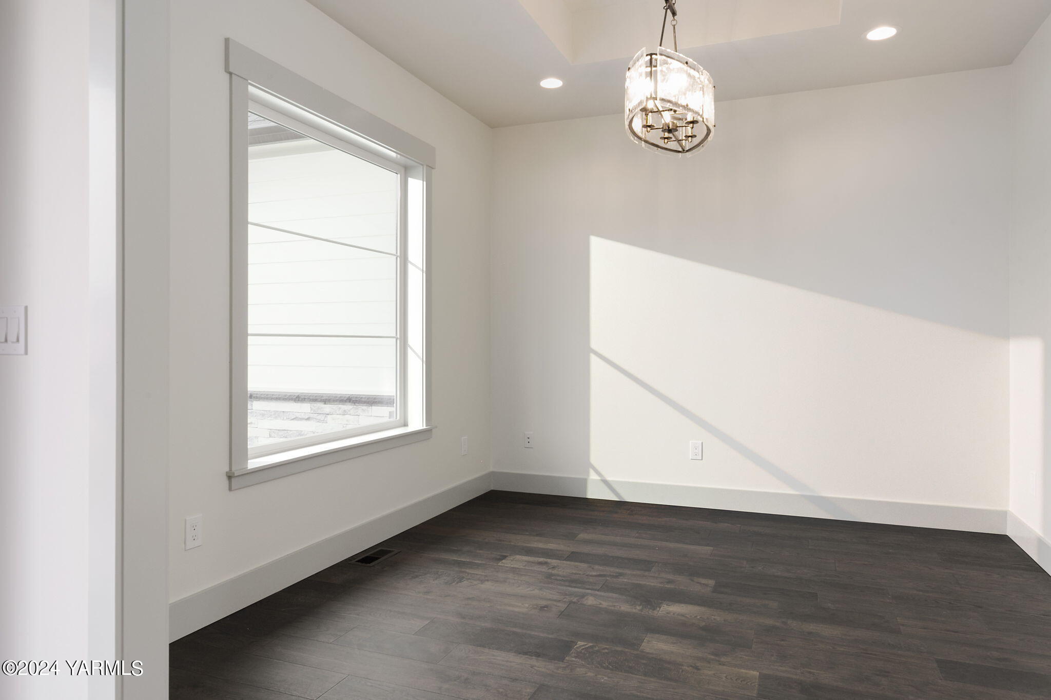 7202 Vista Ridge Avenue Yakima, WA 98903 - Photo 6 of 24 an empty room with wooden floor cabinet and windows
