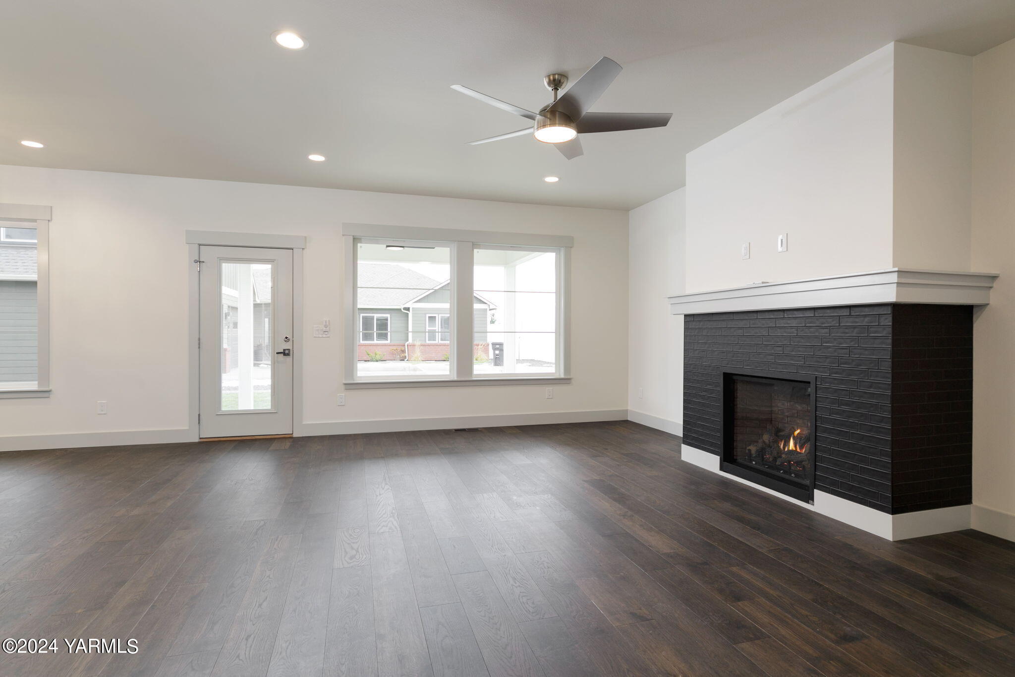 7202 Vista Ridge Avenue Yakima, WA 98903 - Photo 7 of 24 a view of an empty room with wooden floor fireplace and a window