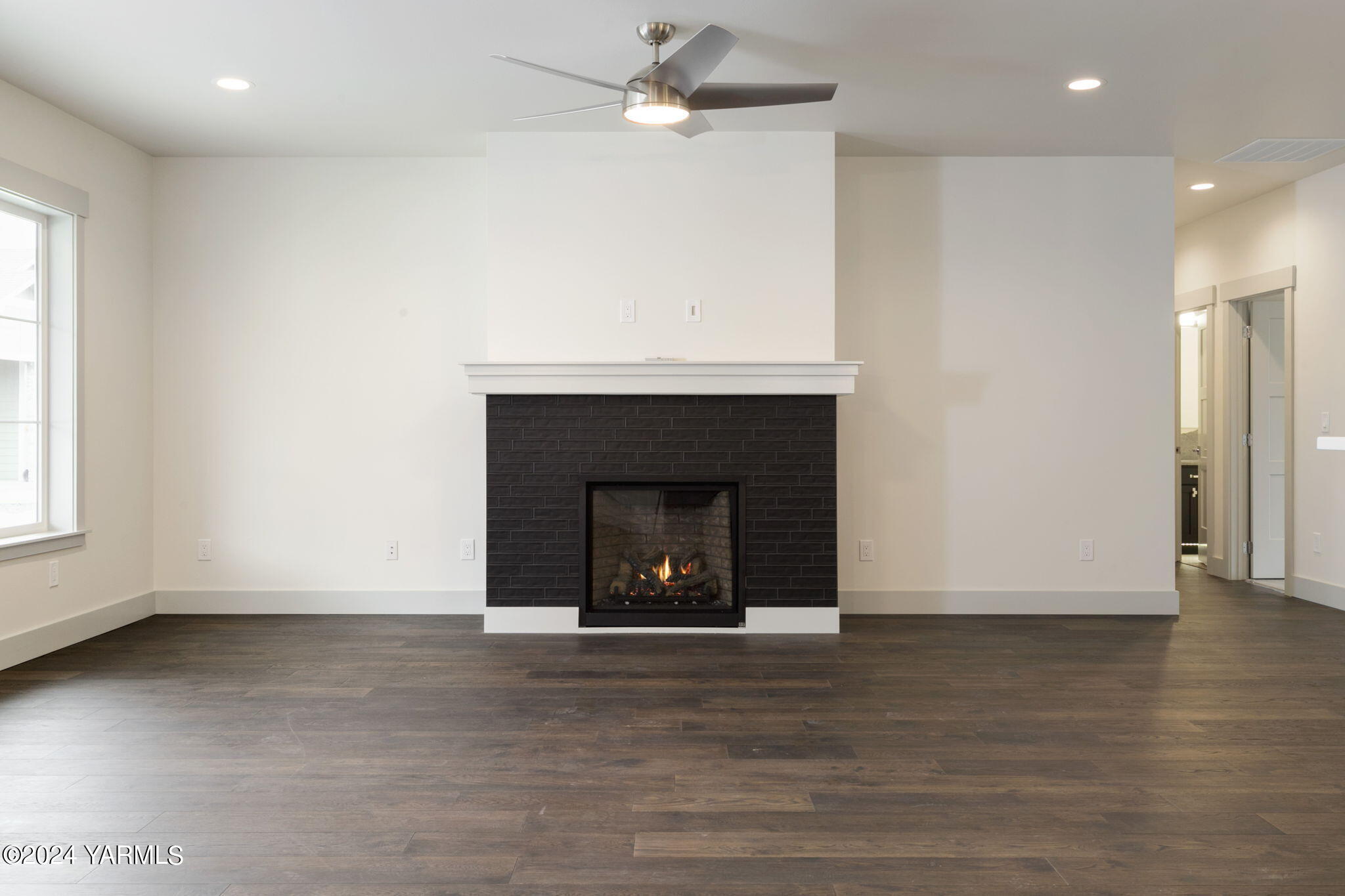 7202 Vista Ridge Avenue Yakima, WA 98903 - Photo 8 of 24 an empty room with wooden floor a fireplace and windows