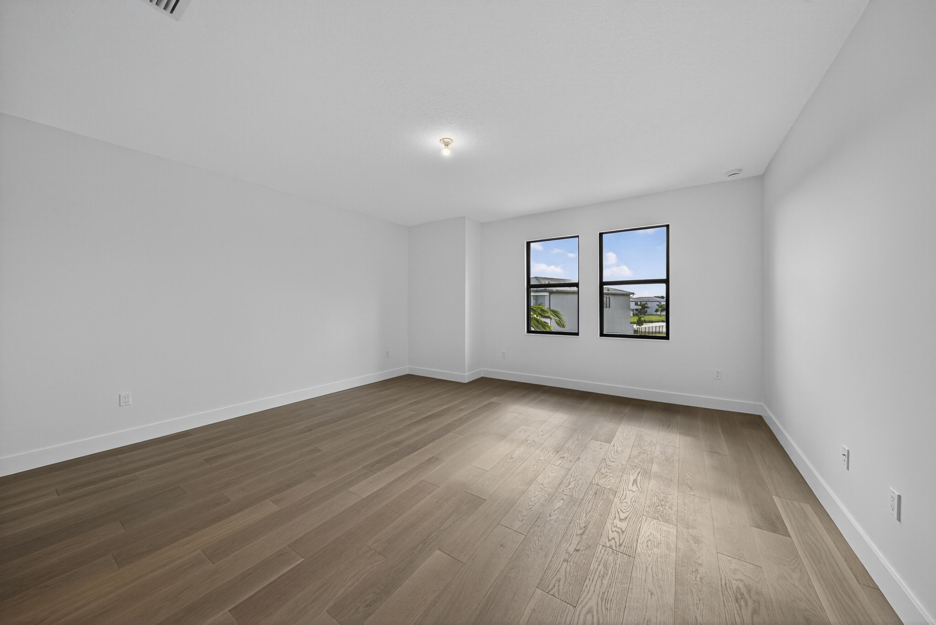 9361 Sunflower Mdw Road Boca Raton, FL 33434 - Photo 22 of 39 an empty room with wooden floor and windows