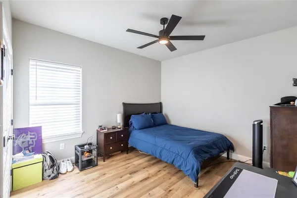 a bedroom with a bed a dresser and a window