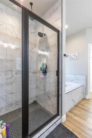 a bathroom with a glass shower door and mirror